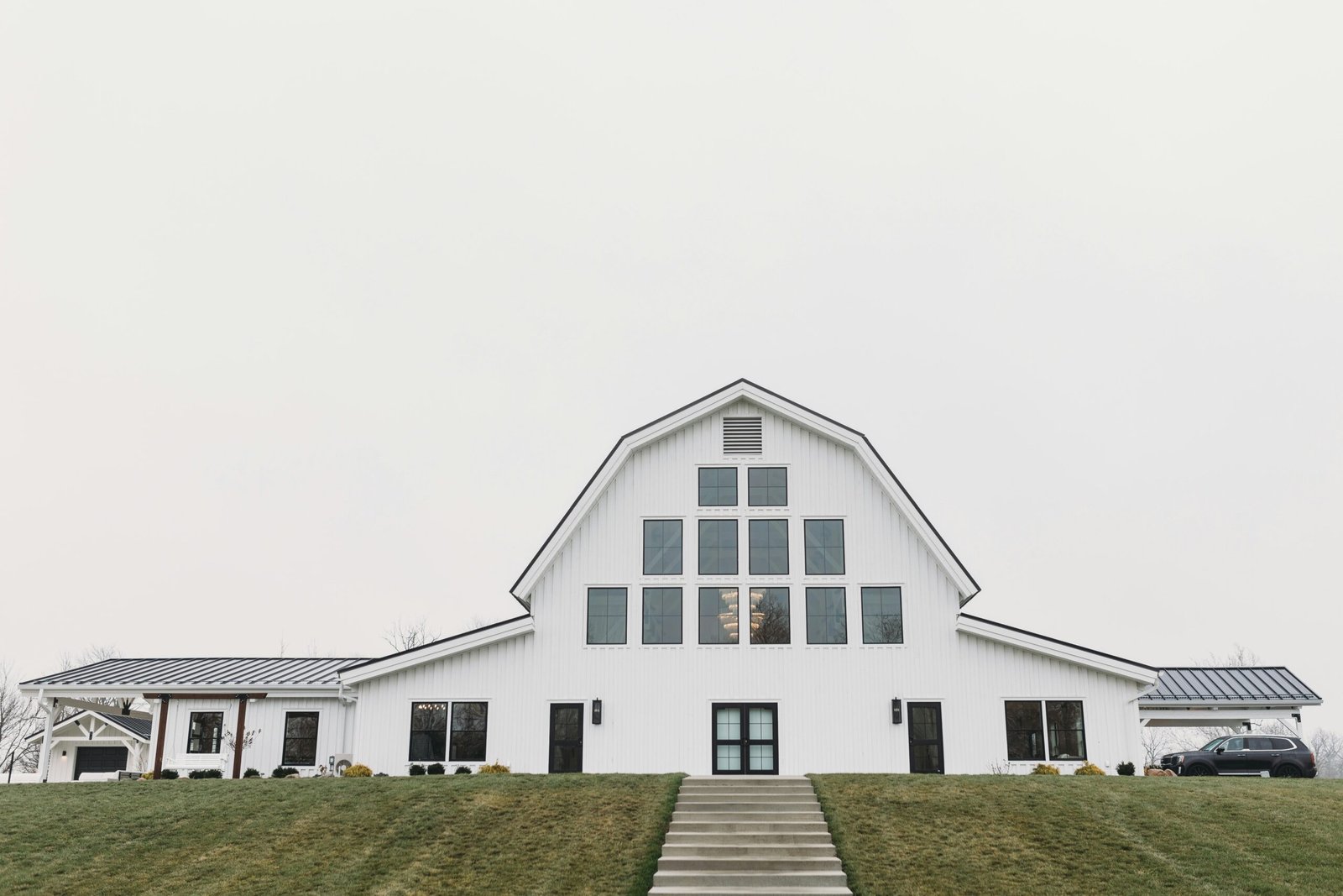 Modern white barn in a rural setting, symbolizing the transformation of rural spaces into event venues by Land Out.